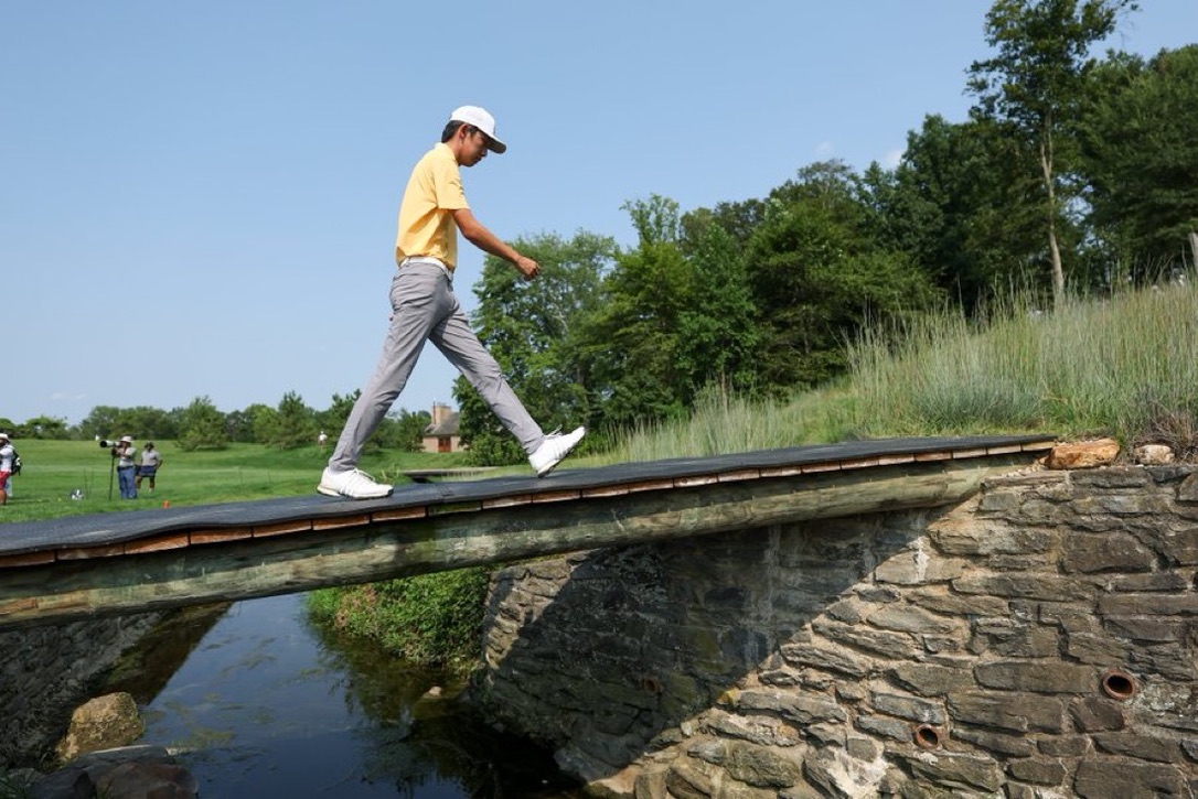 Jay Leng walking across a bridge on a golf course