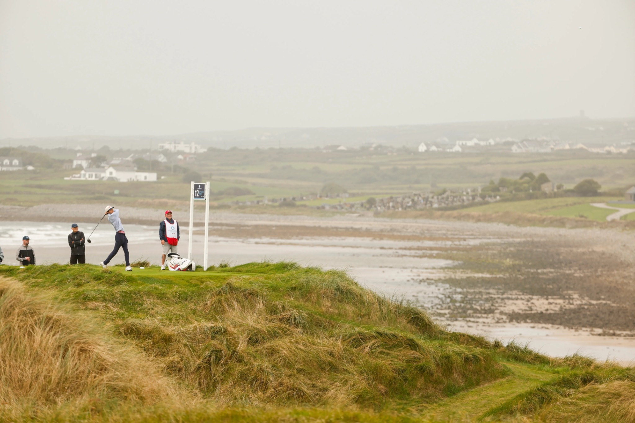 Jay Leng hitting a tee shot on a coastal links course