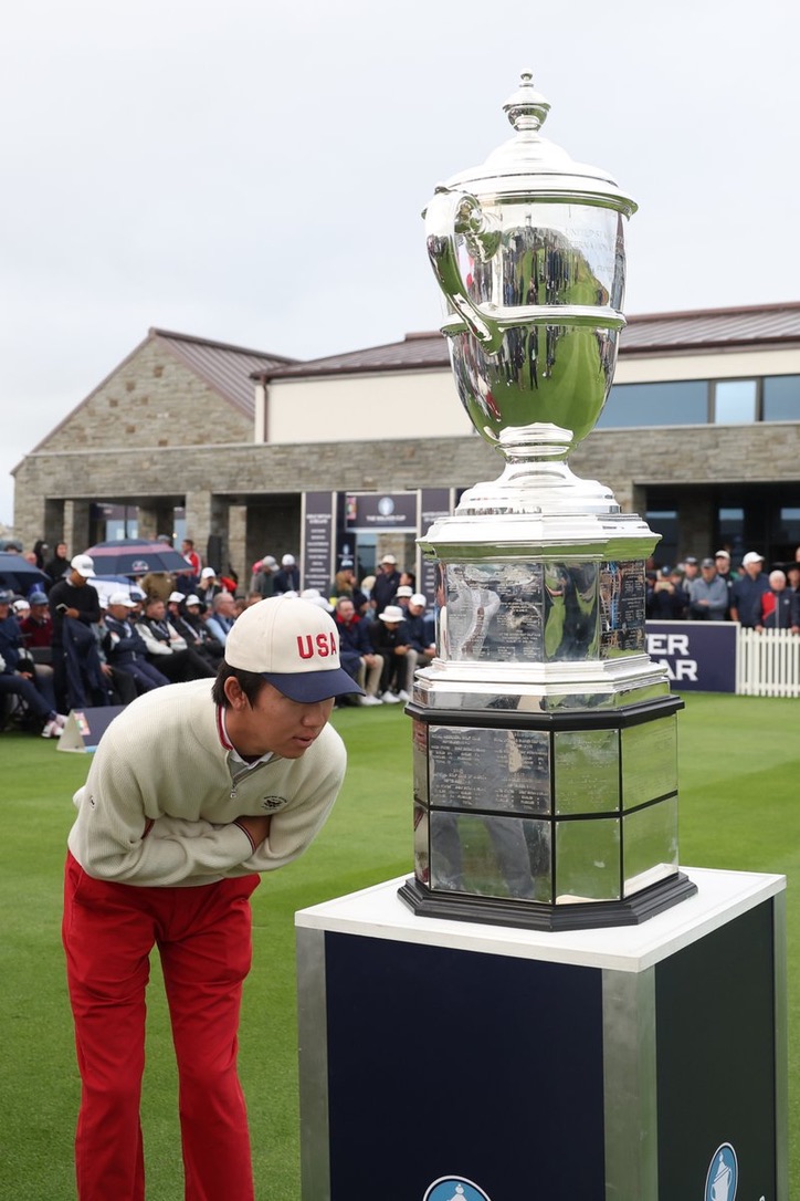 Jay Leng beside a large championship trophy